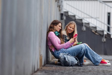 Photo for Young stylish generation Z girls spending time outdoors after school. Young female zoomers talking and gossiping during lunch break in the school. Concept of power of friendship and importance of - Royalty Free Image