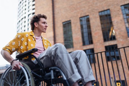 Téléchargez les photos : Gen Z garçon en fauteuil roulant dans la ville. Inclusion, égalité et diversité entre les générations Z. - en image libre de droit