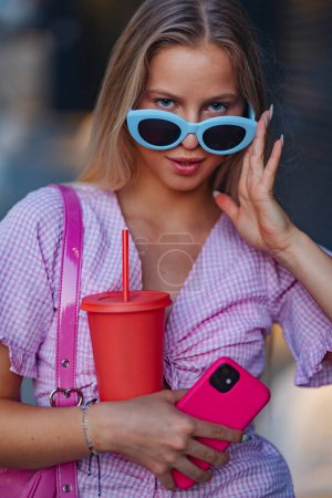 Foto de Retrato de gen Z chica en traje rosa antes de ir al cine a ver la película. La joven chica del zoomer vio una película que abordaba el tema de las mujeres, su posición en el mundo y su imagen corporal. - Imagen libre de derechos