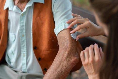 Photo for Close up of caregiver helping senior diabetic man to apply continuous glucose monitor sensor on his arm. Diabetic senior using continuous glucose monitor. - Royalty Free Image