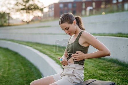 Téléchargez les photos : Femme injectant de l'insuline dans son abdomen à l'extérieur, dans le parc. Gros plan de la femme atteinte de diabète de type 1 prenant isolant avec aiguille de seringue. - en image libre de droit