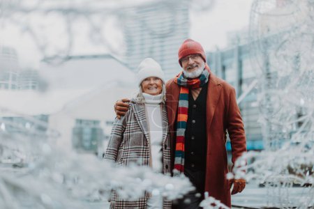 Photo for Elegant senior couple walking near a river, during cold winter day. - Royalty Free Image
