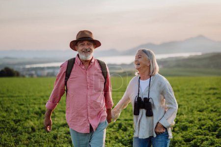 Téléchargez les photos : Portrait de couple de personnes âgées marchant dans la nature automnale. Les conjoints âgés vont cueillir des champignons. - en image libre de droit
