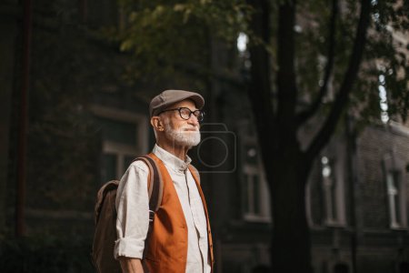 Photo for Senior tourist exploring a new city, exploring interesting places. Portrait of elderly man with beret. Traveling and trips in retirement. - Royalty Free Image