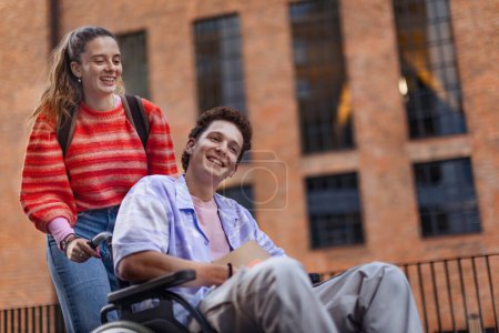 Photo for Handsome gen Z boy in a wheelchair with friend in the city. Inclusion, equality, and diversity among Generation Z. - Royalty Free Image