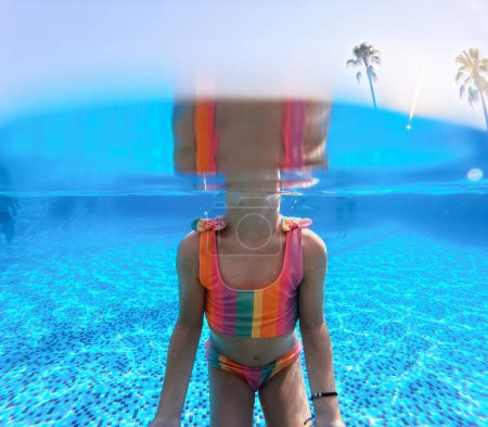 Téléchargez les photos : Photographie sous-marine de fille jouant dans l'eau dans la piscine pendant les vacances d'été. Vacances d'hiver ou d'été au bord de la mer. Vacances à la plage en bord de mer. - en image libre de droit
