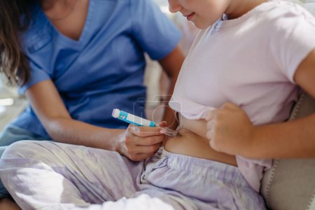 Foto de Enfermera inyectando insulina en vientre de niña diabética. Primer plano de una niña con diabetes tipo 1 que toma insulina con aguja de jeringa. - Imagen libre de derechos