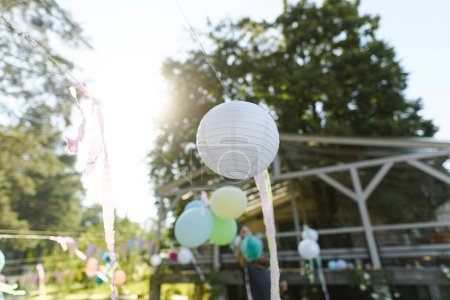 Téléchargez les photos : Gros plan d'une lanterne en papier lors d'une garden party. Idées pour des décorations élégantes simples pour barbecue en plein air, jardin ou grillades. - en image libre de droit