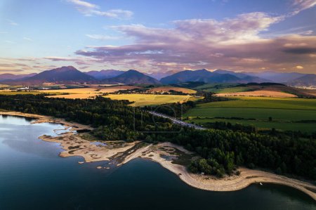 Photo for Aerial view from above the water surface of Liptovska Mara water reservoir on serene nature landscape, Low Tatras in the distance. - Royalty Free Image