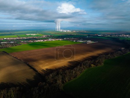 Photo for Aerial view of nuclear power plant with towering cooling towers emitting steam. - Royalty Free Image
