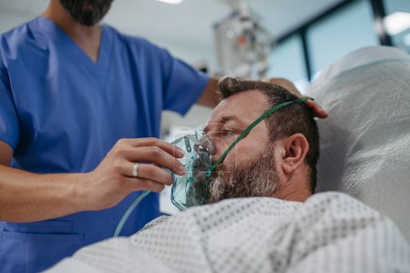 Foto de Enfermera colocando una máscara de oxígeno en el paciente en la cama del hospital. Hombre en unidad de cuidados intensivos en el hospital. - Imagen libre de derechos
