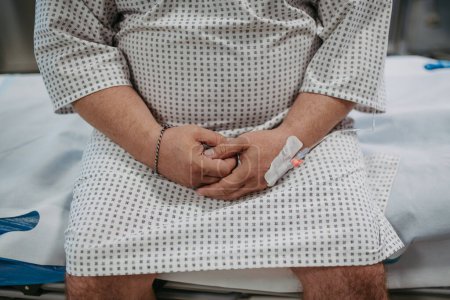 Téléchargez les photos : Vue arrière du patient en surpoids en robe d'hôpital attendant l'examen médical, les résultats des tests à l'hôpital, se sentant anxieux, inquiet et effrayé. - en image libre de droit