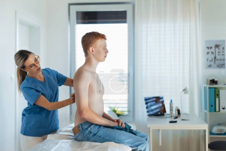 Photo for Female doctor examining teenage boys skin, checking acne and moles. Skin cancer screening. Boy visiting dermatologist for annual preventive skin exam. Concept of preventive health care for - Royalty Free Image