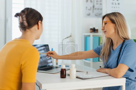 Photo for Teenage girl discussing test results with paediatrician. Doctor prescribing medication to ill teenage girl. Concept of preventive health care for adolescents. - Royalty Free Image