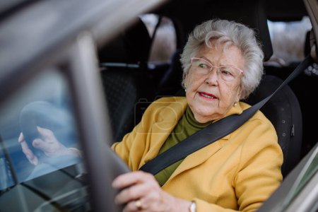 Foto de Mujer mayor centrada conduciendo coche solo y disfrutando de paseo en coche. Conducción segura para adultos mayores, seguridad para conductores mayores. - Imagen libre de derechos