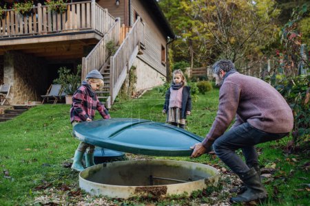 Die Familie überprüft die Wasserqualität im häuslichen Abwasser- oder Abwassersystem. Konzept eines nachhaltigen Familienlebens.