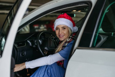 Photo for Beautiful nurse with christmas hat finishing a shift at the hospital and going home. Working in hospital on Christmas day or Christmas Eve. Female doctor arriving at Christmas shift and cant be with - Royalty Free Image