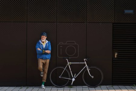 Foto de Un anciano, ciclista que viaja en bicicleta por la ciudad. Viajero de la ciudad mayor vital montar en bicicleta, hacer ejercicio. - Imagen libre de derechos