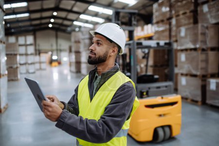 Photo for Portrait of warehouseman with tablet checking delivery, stock in warehouse. Warehouse manager using warehouse management software, app. - Royalty Free Image