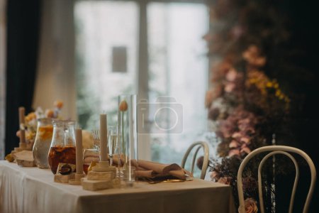 Photo for Elegant, clean, easy table setting for indoor party, wedding reception with luxury, big flower decoration on wall. Special event table set up with fresh flowers arragements. - Royalty Free Image