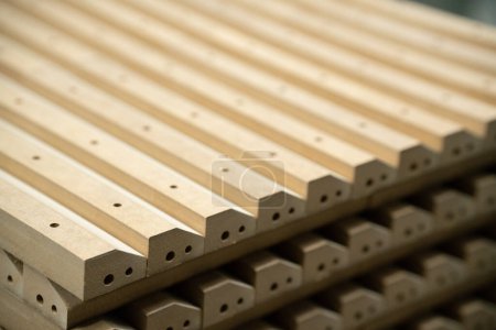 Foto de Cierre de piezas de madera en grandes instalaciones de fabricación de muebles. Partes de madera para la producción de sillas, mesas o camas en el almacén de una fábrica de muebles. - Imagen libre de derechos