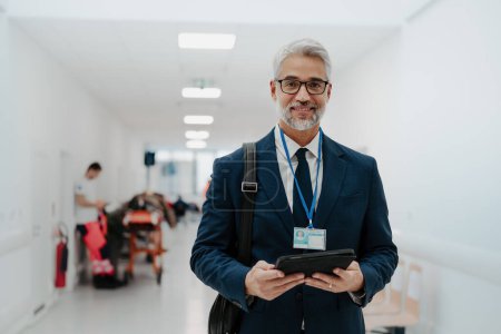 Photo for Portrait of pharmaceutical sales representative in medical building, waiting for doctor, presenting new pharmaceutical product. Smiling drug rep standing in hall, modern medical clinic, holding tablet - Royalty Free Image