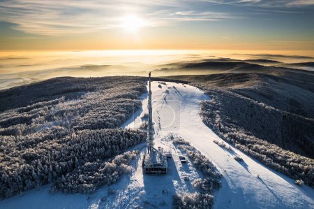 Téléchargez les photos : Vue aérienne d'un émetteur, tour cellulaire entourée d'une forêt en hiver. Vue par drone du paysage enneigé, concept des vacances de Noël d'hiver. - en image libre de droit