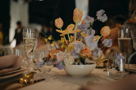 Foto de Elegante y romántico entorno de mesa para la recepción de la boda de primavera interior o fiesta. Decoración de mesa de boda de lujo, mesa de eventos especiales con arreglos de flores frescas de primavera. - Imagen libre de derechos