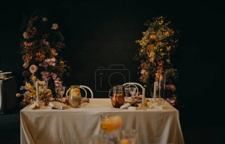 Foto de Elegante, limpio, ajuste fácil de la mesa para la fiesta de interior, recepción de la boda con el lujo, decoración grande de la flor en pared. Mesa especial para eventos con arreglos de flores frescas. - Imagen libre de derechos