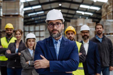 Photo for Full team of warehouse employees standing in warehouse. Team of workers, managers and male director in modern industrial factory, heavy industry, manufactrury. Group portrait. - Royalty Free Image