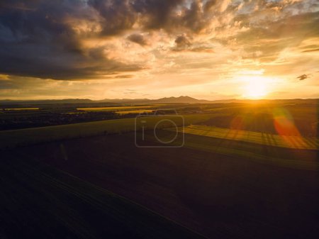 Téléchargez les photos : Vue aérienne d'une prairie, d'une forêt et de champs au coucher du soleil. - en image libre de droit
