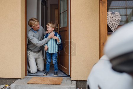 Photo for Boy getting ready for school, putting on the shoes, getting dressed. Father taking son to school before going to work. - Royalty Free Image