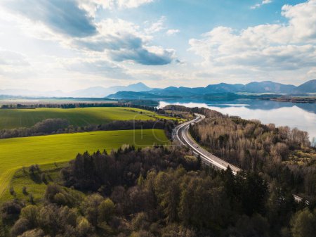 Foto de Vista aérea de la naturaleza verde de verano con lago, cultivos o pastos con carretera y montañas. - Imagen libre de derechos