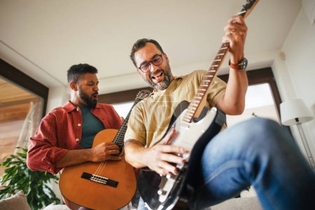 Photo for Best friends, musician jamming together. Playing music on acoustic and electric guitar together, having fun. Concept of male friendship, bromance. - Royalty Free Image