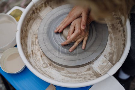 Photo for Close up of mother teaching son how to make pottery on pottery wheel. Child creative activities and art. Boy making pottery, having fun with mom. Happy family moment. - Royalty Free Image