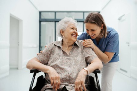 Téléchargez les photos : Portrait d'une infirmière soignante et d'une patiente âgée parlant dans un couloir d'hôpital. Soutien émotionnel pour les femmes âgées. - en image libre de droit