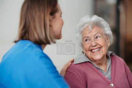 Foto de Retrato de enfermera y paciente mayor que habla en el pasillo del hospital. Apoyo emocional para la mujer anciana. - Imagen libre de derechos