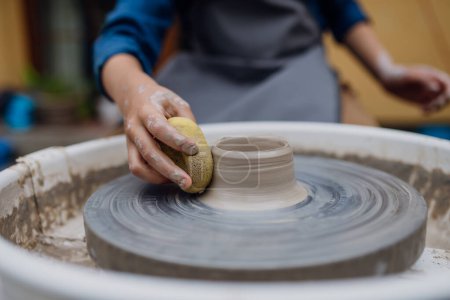 Photo for Close up woman making pottery on pottery wheel. Child creative activities and art. Boy making pottery with mom, having fun. Happy family moment. - Royalty Free Image