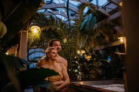 Téléchargez les photos : Beau couple debout dans la serre de l'hôtel, profitant d'un week-end bien-être romantique dans le spa. Concept de Saint Valentin. - en image libre de droit