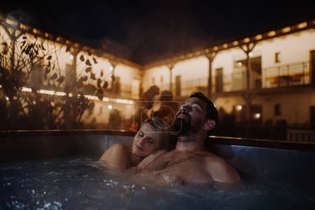 Téléchargez les photos : Beau couple mature relaxant dans un bain à remous extérieur, profitant d'un week-end bien-être romantique dans le spa. Concept de Saint Valentin. - en image libre de droit