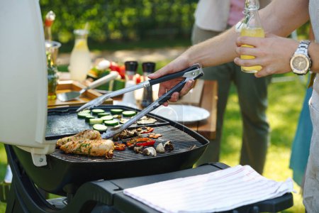 Meat and vegetables grilling on an outdoor grill. Outdoor grill or BBQ party in the garden.