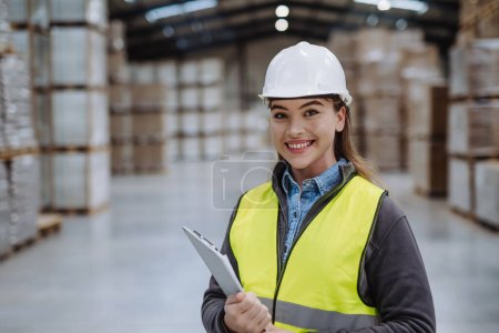 Photo for Female warehouse worker reading product order, order picking. Warehouse manager checking delivery, stock in warehouse, inspecting products for the shipment. - Royalty Free Image