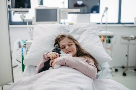 Téléchargez les photos : Petite fille patiente allongée dans un lit d'hôpital. Enfants en unité de soins intensifs à l'hôpital dormant. Bannière avec espace de copie. - en image libre de droit