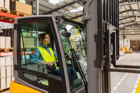 Photo for Portrait of female warehouse worker driving forklift. Warehouse worker preparing products for shipmennt, delivery, checking stock in warehouse. - Royalty Free Image