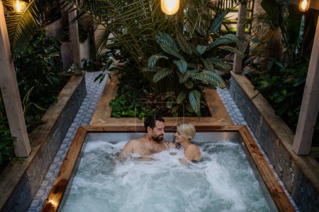Foto de Hermosa pareja madura relajándose en la bañera de hidromasaje, disfrutando de un romántico fin de semana de bienestar en el spa. Concepto de Día de San Valentín. - Imagen libre de derechos
