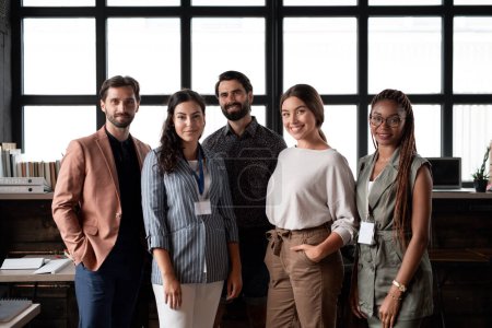 Photo for Group of colleagues standing in modern office, looking at camera. Concept of teamwork, diverse team for business, startups. Team portrait. - Royalty Free Image