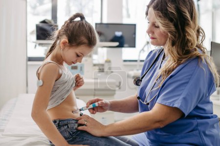 Nurse injecting insulin in diabetic young girl belly. Close up of young girl with type 1 diabetes taking insuling with syringe needle.