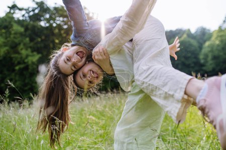 Dos hermanas jugando en el prado en la hierba alta, divirtiéndose, apoyándose mutuamente. Hermandad amor y hermanos concepto de relación.