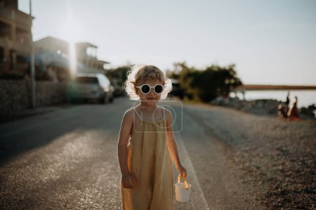 Photo for Portrait of blonde girl in summer outfit and sunglasses on walk during summer vacation, concept of beach holiday. - Royalty Free Image