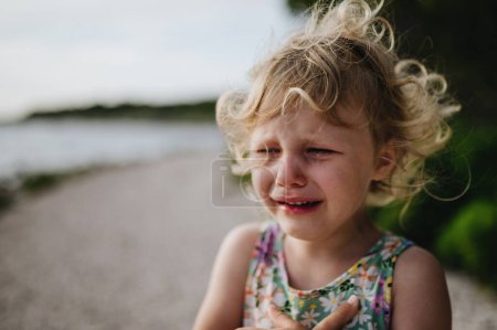 Photo for Portrait of crying blonde girl in summer outfit and sunglasses on walk during summer vacation, concept of beach holiday. - Royalty Free Image